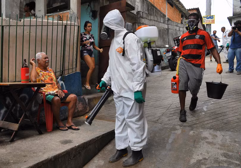 Nhân dân y tế phun thuốc phòng dịch và người dân không mang khẩu trang ở khu phố nghèo (Ảnh: Guancha).