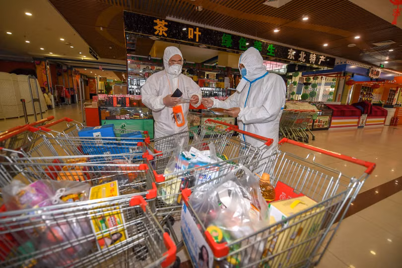 Nhân viên chống dịch kiểm tra hàng hóa các gia đình đặt mua để chuyển cho các hộ đang bị phong tỏa (Ảnh: Tân Hoa xã).