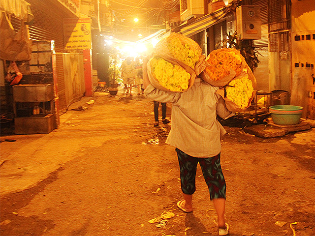 Một mình chị cân cả thế giới hoa trên vai khi hàng vừa xuống xe. Một mình chị cân cả thế giới hoa trên vai khi hàng vừa xuống xe.