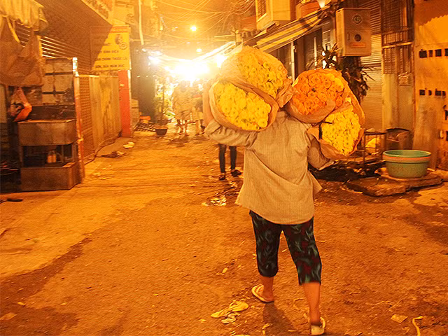 Một mình chị cân cả thế giới hoa trên vai khi hàng vừa xuống xe.