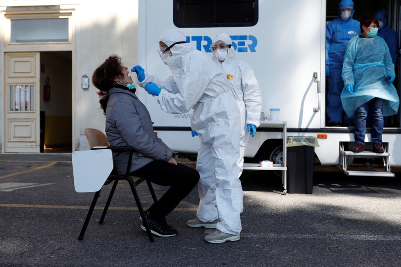 Ngày 1/4, giờ địa phương, tại Rome, một nhân viên y tế mặc đồ bảo hộ đang lấy mẫu của một phụ nữ bị nghi nhiễm bệnh để xét nghiệm virus Corona mới (Ảnh: Reuters).