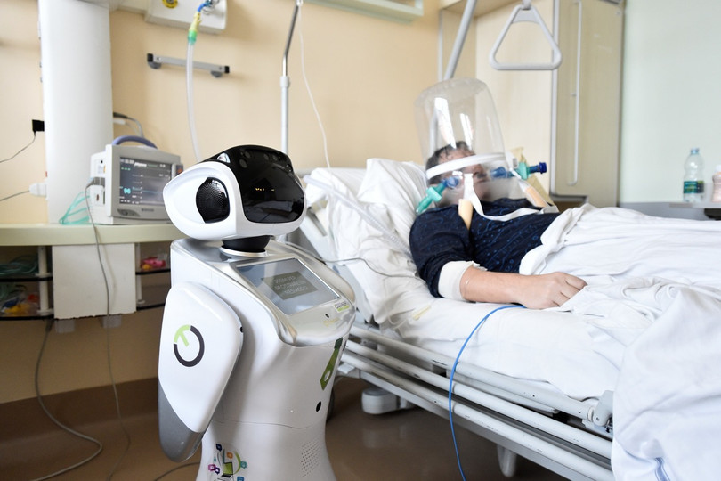 Một y tá robot đang giúp điều trị một bệnh nhân nặng bị viêm phổi do virus Corona mới (Ảnh: Reuters).