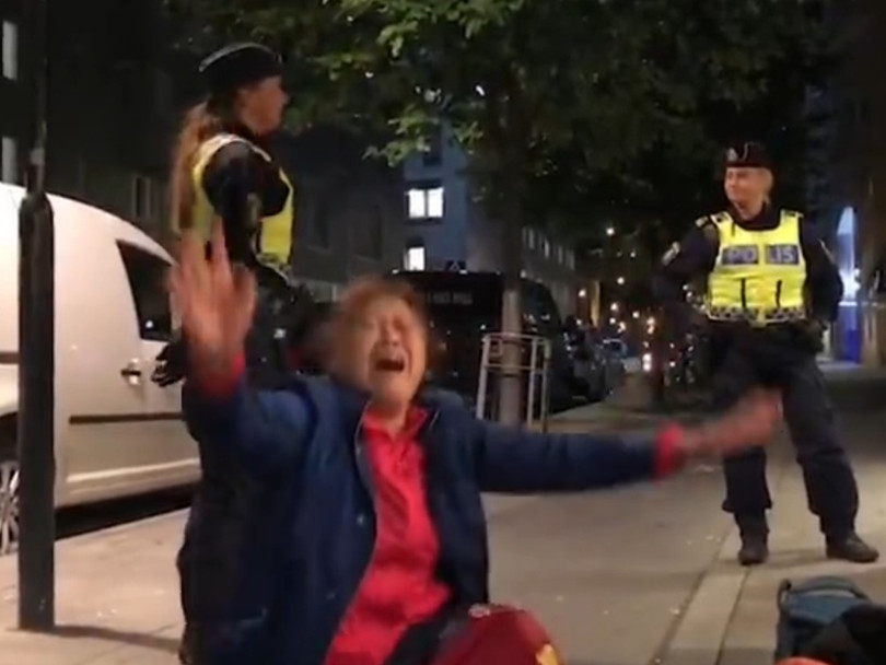 Hình ảnh trích video cho thấy người phụ nữ khóc lóc chửi bới trước sự ngỡ ngàng của các nhân viên cảnh sát Thụy Điển