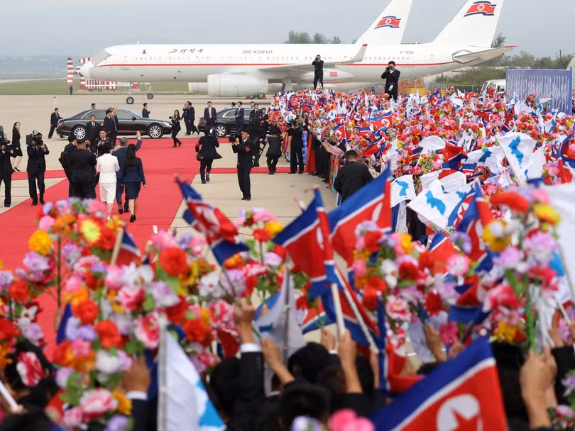 Những người ra đón mang theo hoa, quốc kỳ Triều Tiên và cờ Bán đảo