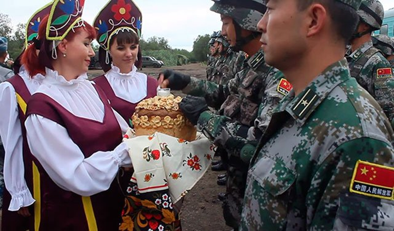 Các cô gái Nga đón binh sĩ Trung Quốc tới tham gia cuộc tập trận. Ảnh: Người quan sát