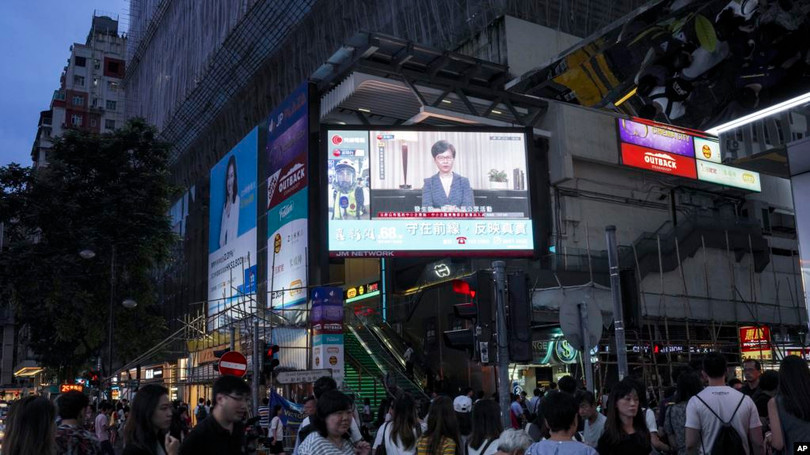 Dân chúng Hồng Kông theo dõi phát biểu của bà Carrie Lam trên truyền hình.