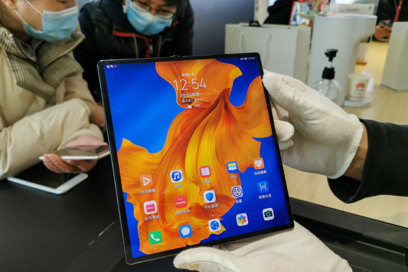 Nhân viên bán hàng đeo găng tay khi giới thiệu smartphone gập Huawei Mate X cho khách hàng hôm 10/3 tại Nam Kinh, Trung Quốc. Ảnh: SIPA Asia