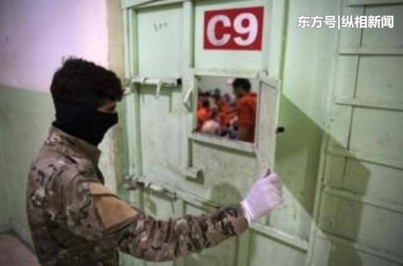 Một binh sỹ người Kurd kiểm tra tù binh IS bị giam giữ trong trại giam.