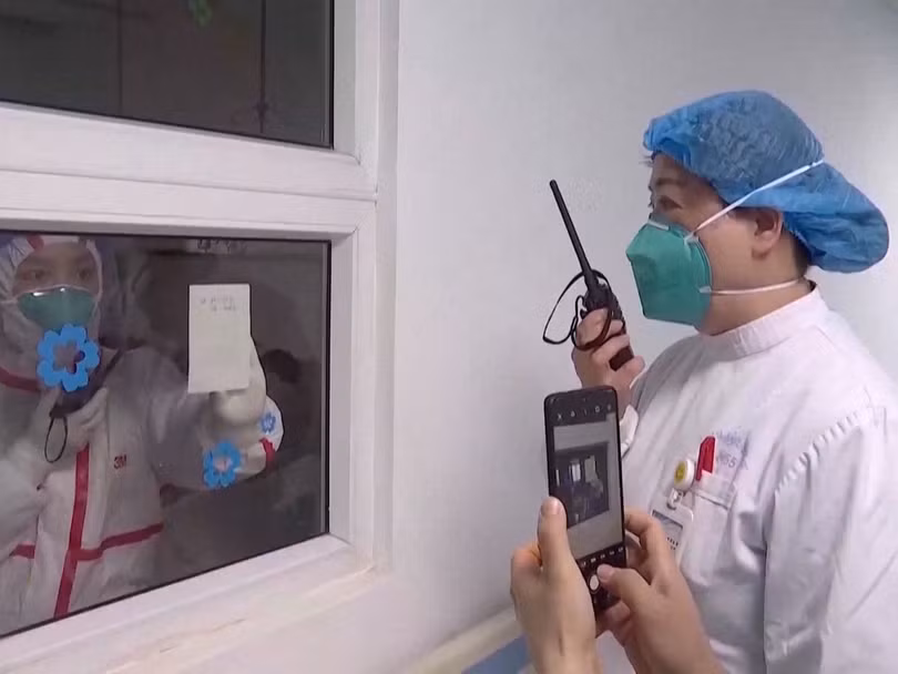 Các nhân viên y tế ở trong và ngoài khu vực điều trị cách ly ở bệnh viện Vũ Hán (Ảnh: Đa Chiều)