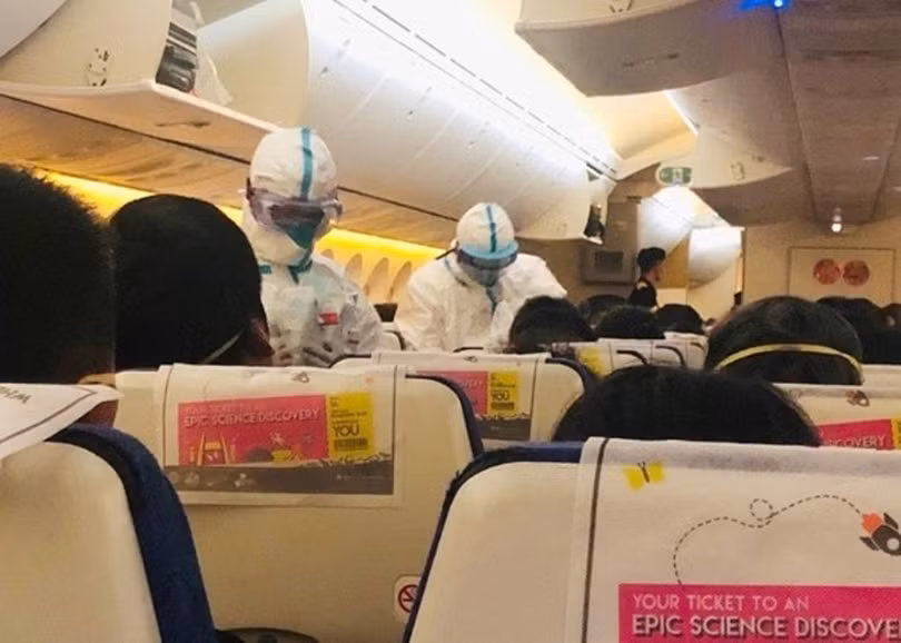 Các nhân viên y tế ơn sân bay Tiêu Sơn, Hàng Châu lên máy bay kiểm tra thân nhiệt của hành khách trên chuyển bay TR118 của háng Scoot (Ảnh: Đông Phương)