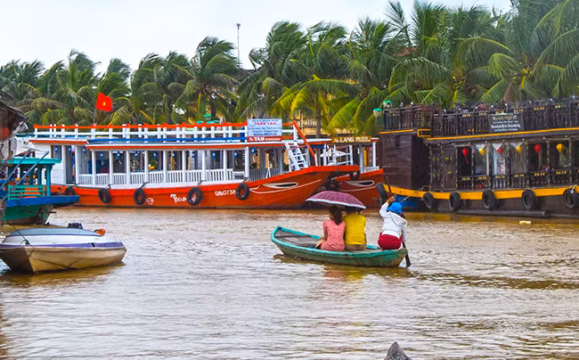 Du khách dong thuyền đi chơi lũ trên sông Hoài