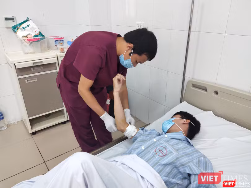 BS. Trần Duy Hiến thăm khám vết thương ở tay cho bệnh nhân. Ảnh: Minh Thúy