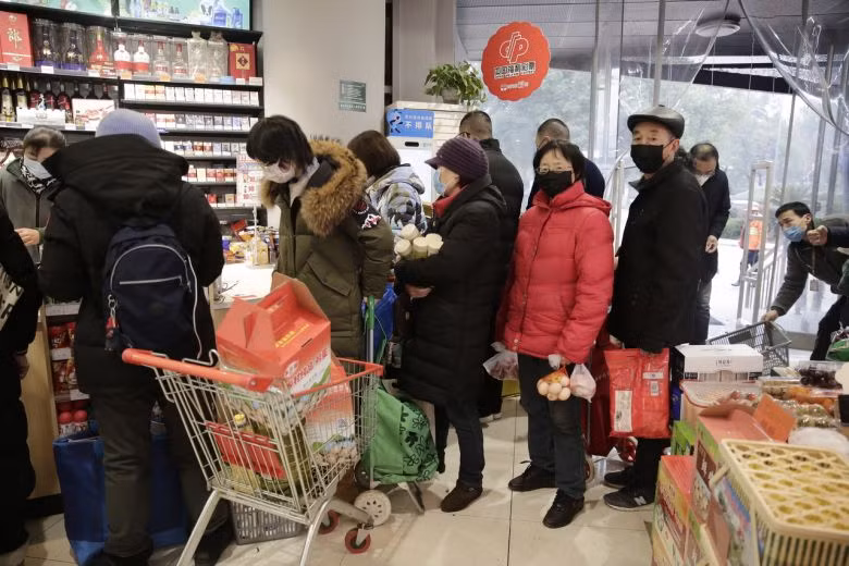 Người dân xếp hàng để mua đồ tạp hóa tại chợ khi giá thực phẩm tăng cao do sự bùng phát của Coronavirus tại thành phố Vũ Hán, Trung Quốc. Ảnh: EPA-EFE Người dân xếp hàng để mua đồ tạp hóa tại chợ khi giá thực phẩm tăng cao do sự bùng phát của Coronavirus tại thành phố Vũ Hán, Trung Quốc. Ảnh: EPA-EFE