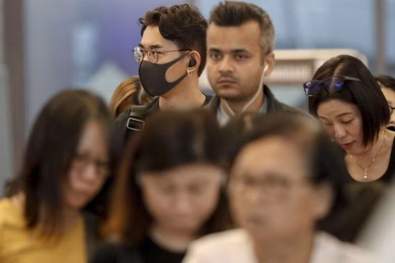 Một khách du lịch đeo khẩu trangrong khi xếp hàng tại quầy làm thủ tục tại sân bay Changi ở Singapore. Ảnh: EPA-EFE Một khách du lịch đeo khẩu trangrong khi xếp hàng tại quầy làm thủ tục tại sân bay Changi ở Singapore. Ảnh: EPA-EFE