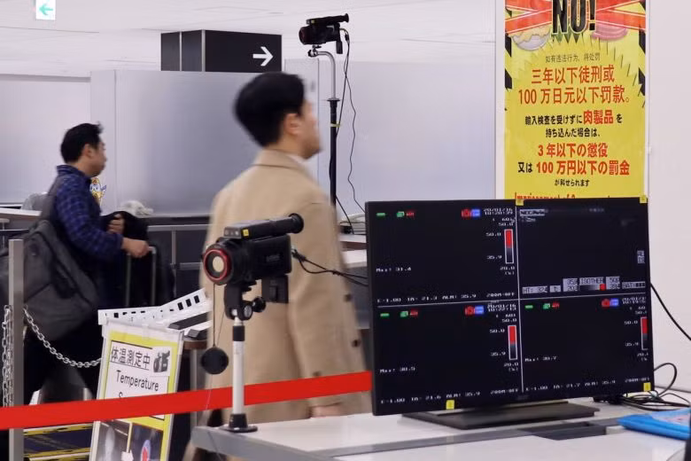 Hành khách đi ngang qua trạm kiểm soát kiểm dịch tại sân bay Narita ở Nhật Bản. Ảnh: EPA-EFE