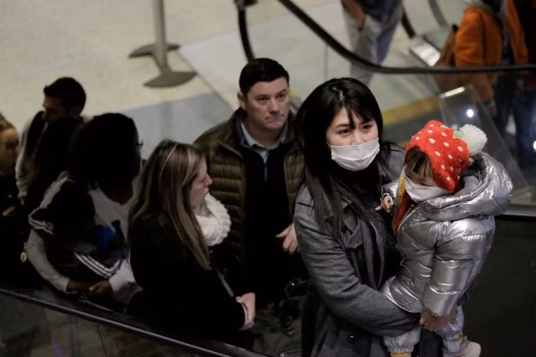 Du khách đeo khẩu trang đến trên chuyến bay trực tiếp từ Trung Quốc tại Sân bay Quốc tế Seattle-Tacoma ở SeaTac, Washington. Ảnh: REUTERS