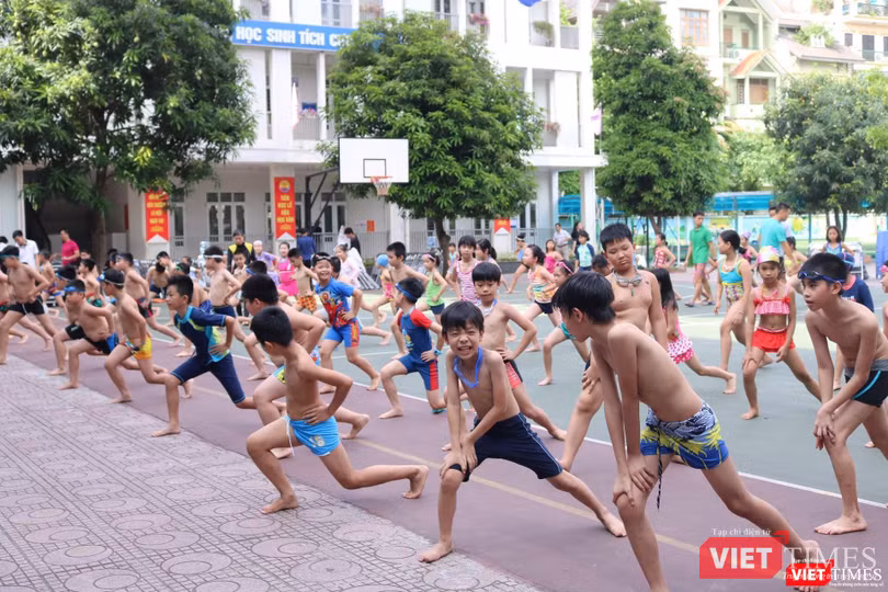 Học sinh khởi động theo hướng dẫn của thầy cô trước khi thực hành môn bơi. Ảnh: Minh Thúy. Học sinh khởi động theo hướng dẫn của thầy cô trước khi thực hành môn bơi. Ảnh: Minh Thúy.