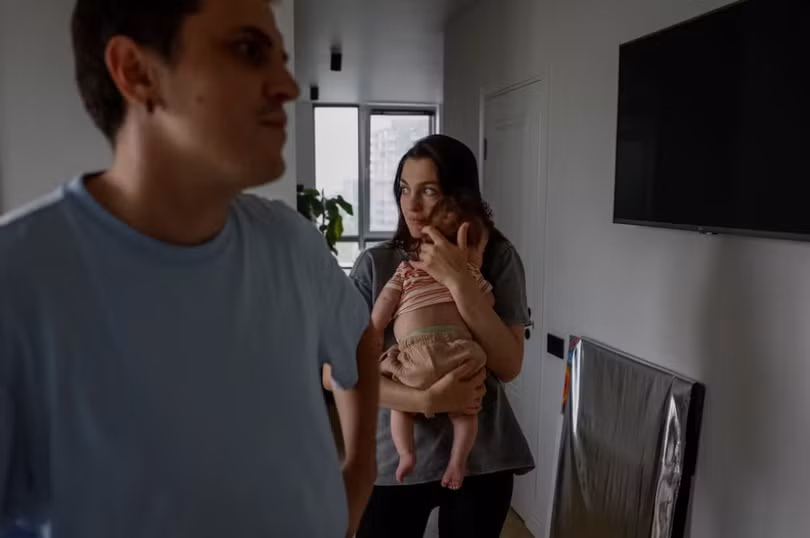 Maryna Tkalich, 33 tuổi, bế đứa con 2 tháng tuổi trong căn hộ của mình khi mất điện ở Kiev, Ukraine, ngày 7/6 (Ảnh: Reuters)