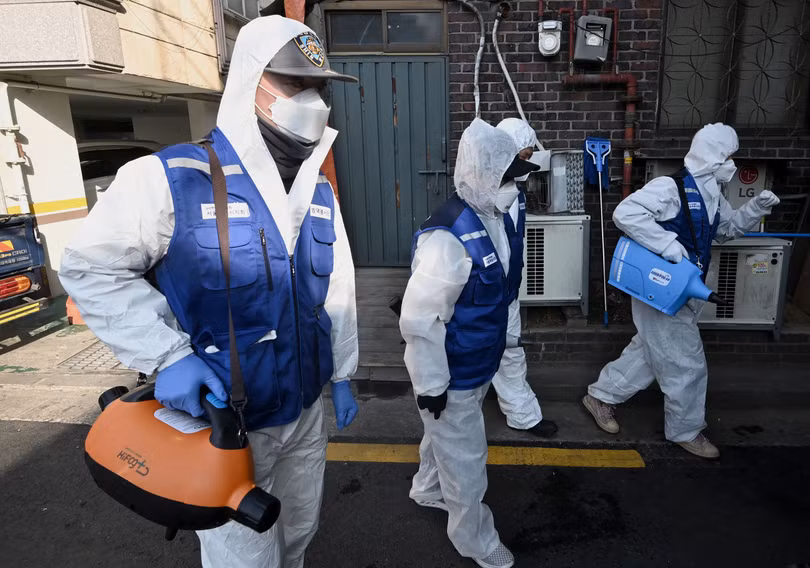 Các nhân viên phun thuốc phòng dịch tại một khu chợ ở thủ đô Seoul, Hàn Quốc (Ảnh: AFP)