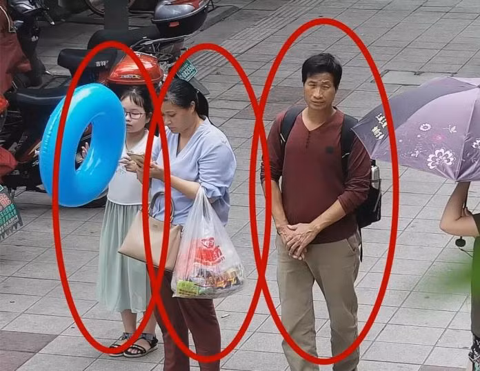 Bức ảnh trích xuất từ camera an ninh cho thấy cô bé Zhang Zixin bị 2 người lớn dẫn đi (Ảnh: Getty)