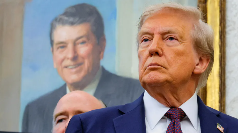 Tổng thống Donald Trump, trước bức tranh của cố Tổng thống Ronald Reagan, tại Phòng Bầu dục ở Nhà Trắng ở Washington, D.C. Ảnh: Reuters.