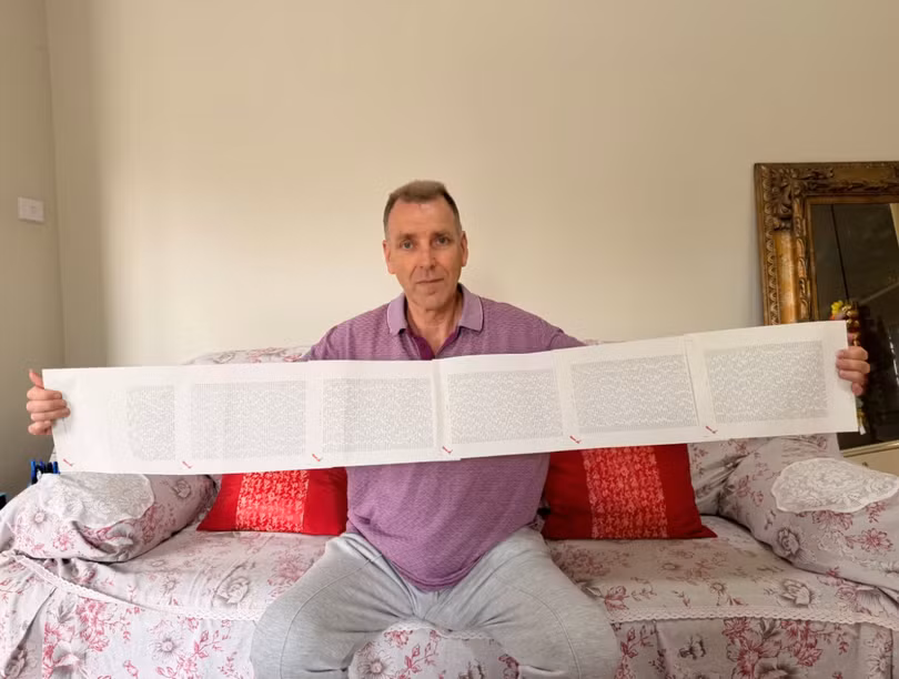 Laurence Watkins, một nhân viên bảo vệ đã nghỉ hưu đến từ Auckland, New Zealand, cầm trên tay giấy khai sinh dài 6 trang, trong đó ghi đầy đủ 2.253 cái tên của ông. Ảnh: CNN.