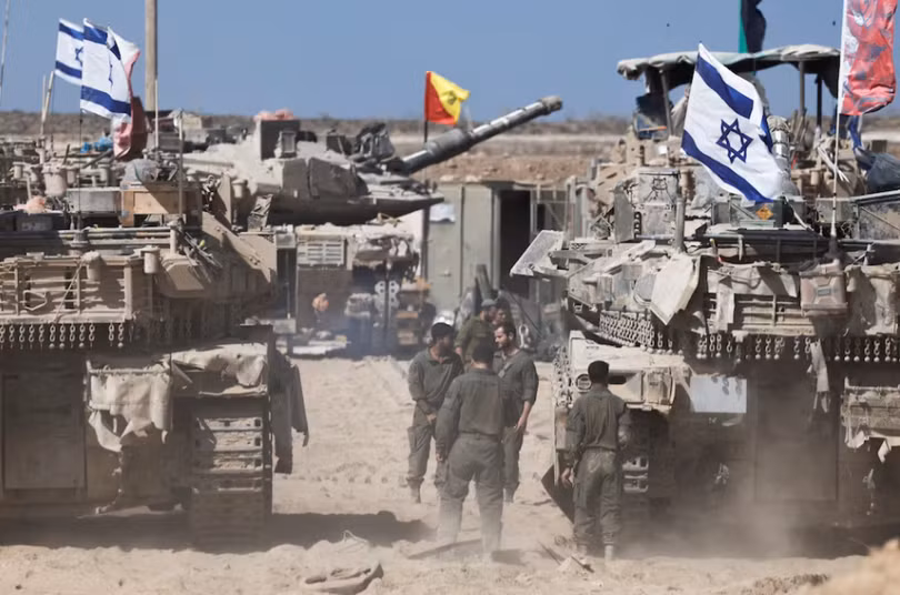 Binh sĩ Israel đứng cạnh xe tăng gần biên giới Israel-Gaza, tại Israel, ngày 19/10. Ảnh: Reuters.