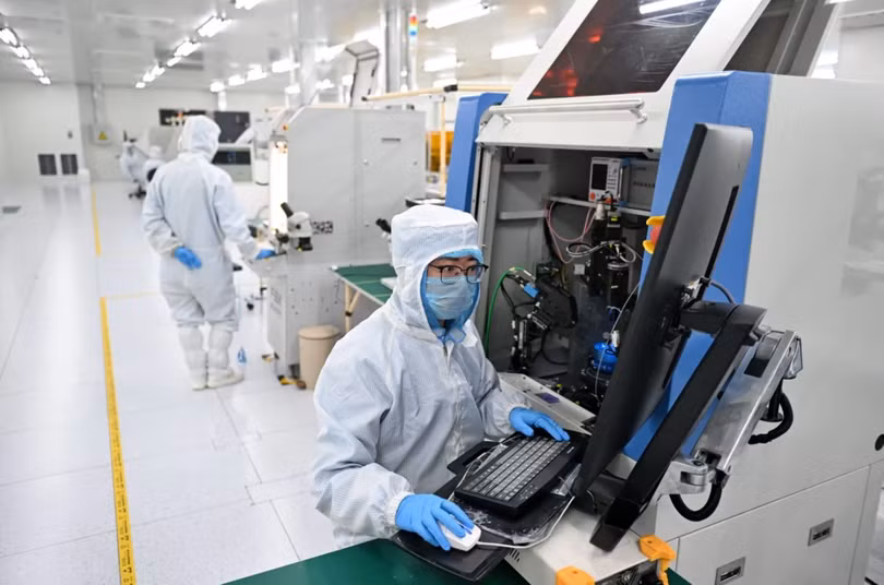 Nhân viên làm việc tại một xưởng sản xuất chip ở tỉnh Hà Bắc, miền Bắc Trung Quốc. Chính quyền địa phương Trung Quốc đang đổ tiền đầu tư vào lĩnh vực bán dẫn trong bối cảnh cạnh tranh để vươn lên trở thành siêu cường sản xuất chip. Ảnh: Xinhua.