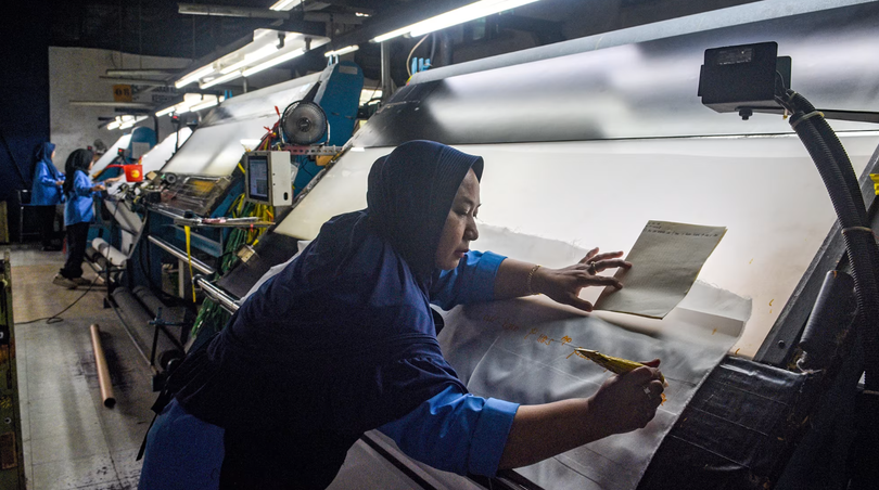 Một công nhân kiểm tra vải xuất khẩu trước khi nhuộm tại nhà máy Trisula Textile Industries ở Cimahi, Tây Java vào ngày 15/4. Ảnh: AFP.