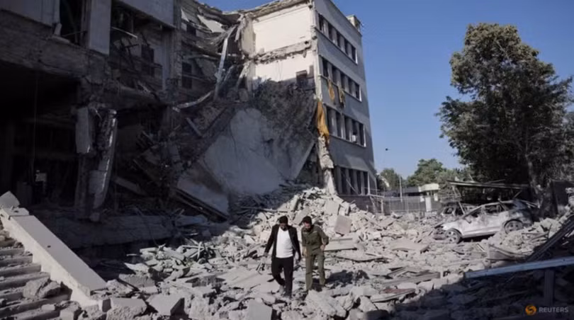 Người dân đi bộ giữa đống đổ nát sau cuộc không kích mạnh mẽ của Israel làm rung chuyển Damascus vào ngày 16/7. Ảnh: Reuters.