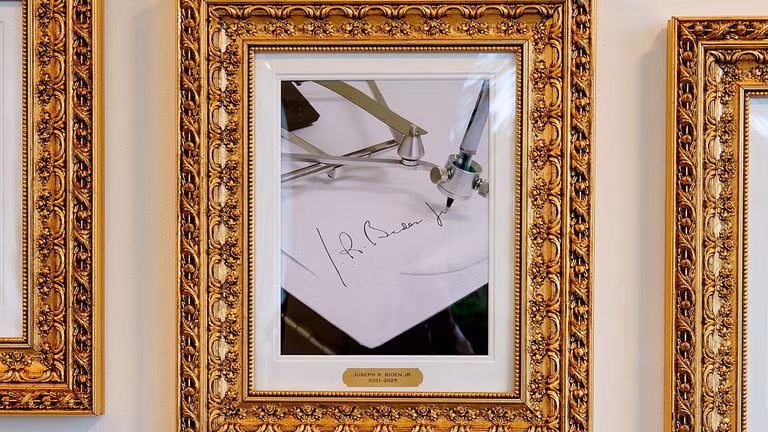 Ảnh chân dung ông Joe Biden bị ông Trump thay bằng một chiếc máy ký tự động. Ảnh: Getty.