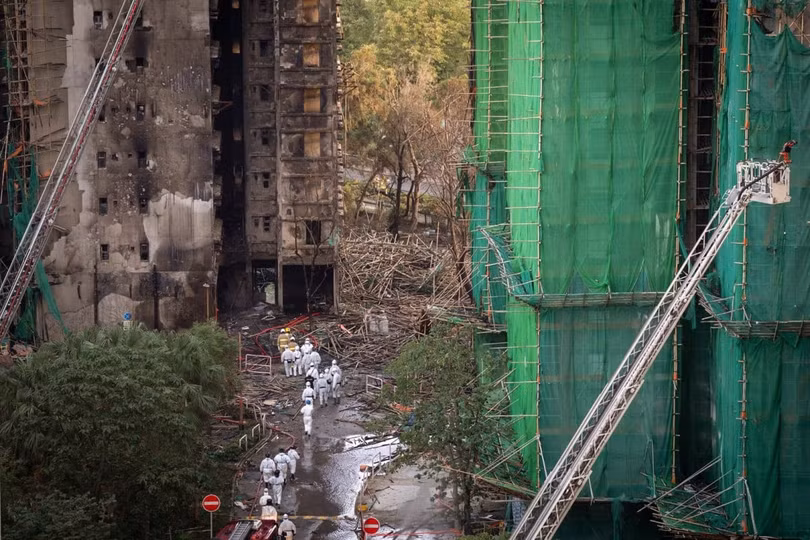 Các thành viên của Đơn vị nhận diện nạn nhân thảm họa có mặt tại hiện trường vụ hỏa hoạn ở Hong Kong. Ảnh: SCMP.