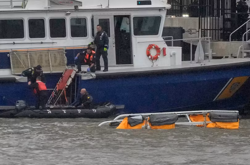 Các nhân viên cứu hộ làm việc tại hiện trường vụ rơi trực thăng trên sông Hudson, New York, ngày 10/4. Ảnh: Reuters.