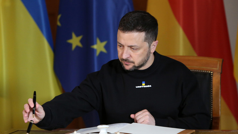 Tổng thống Ukraine Volodymyr Zelensky đang ký vào một cuốn sổ lưu bút. Ảnh: Getty.