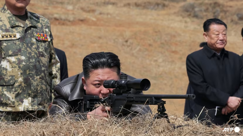 Nhà lãnh đạo Triều Tiên Kim Jong-un đang nhìn qua ống ngắm súng bắn tỉa khi ông đến thăm căn cứ huấn luyện của lực lượng tác chiến đặc biệt của Quân đội Nhân dân Triều Tiên. Ảnh: AFP.
