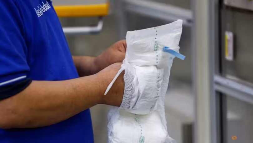 Một nhân viên làm việc trên dây chuyền sản xuất tã lót người lớn tại nhà máy Elleair, công ty con của Daio Paper Corporation ở Fujinomiya, Shizuoka, Nhật Bản (Ảnh: Reuters)