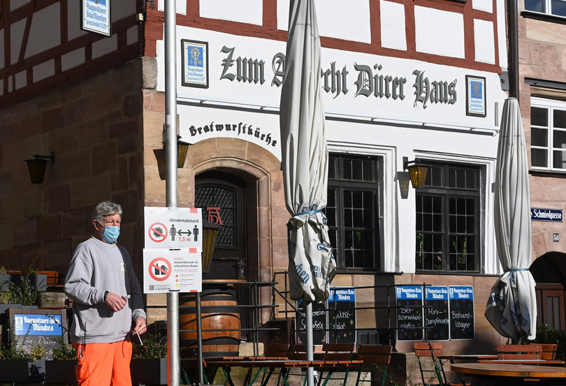 Một người dân đứng cạnh tấm biển hướng dẫn phòng chống COVID-19 ở Nuremberg, Đức (Ảnh: NBC) Một người dân đứng cạnh tấm biển hướng dẫn phòng chống COVID-19 ở Nuremberg, Đức (Ảnh: NBC)