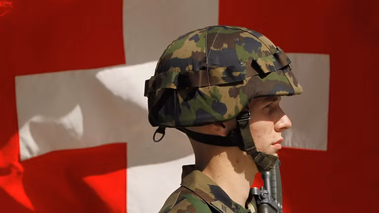 Một người lính Thụy Sĩ đứng trước lá quốc kỳ (Ảnh: Getty)