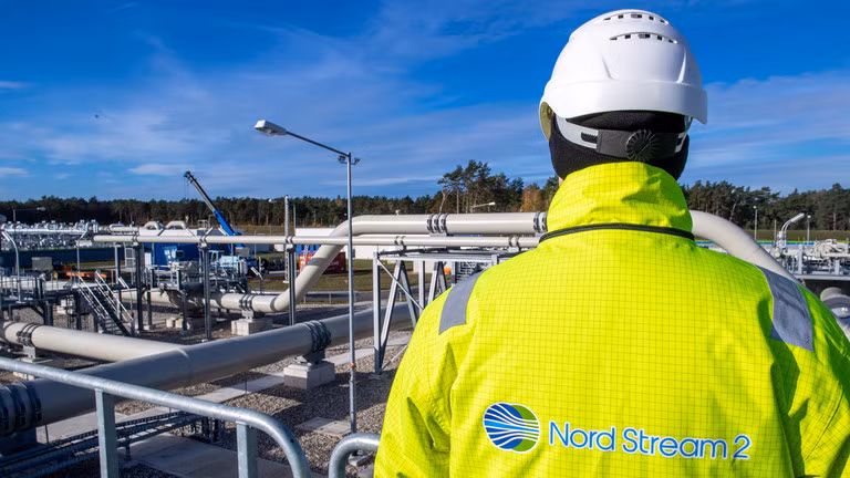 Một công nhân đứng bên cạnh một phần của đường ống Nord Stream 2. Ảnh: Getty.