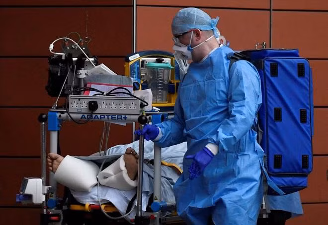 Một nhân viên y tế Anh chăm sóc bệnh nhân Covid-19 (Ảnh Reuters)