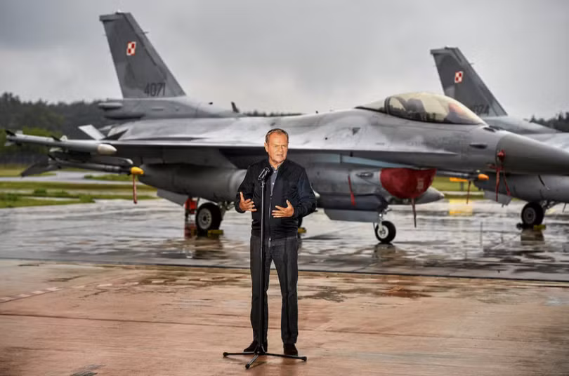 Thủ tướng Ba Lan Donald Tusk đứng trước các máy bay chiến đấu F-16 của Không quân Ba Lan khi ông tổ chức họp báo về mối đe dọa từ UAV Nga tại Căn cứ Không quân Chiến thuật số 32 ở Lask, cách Lodz, Ba Lan khoảng 30 km về phía tây nam, ngày 11/9. Ảnh: Reuters.