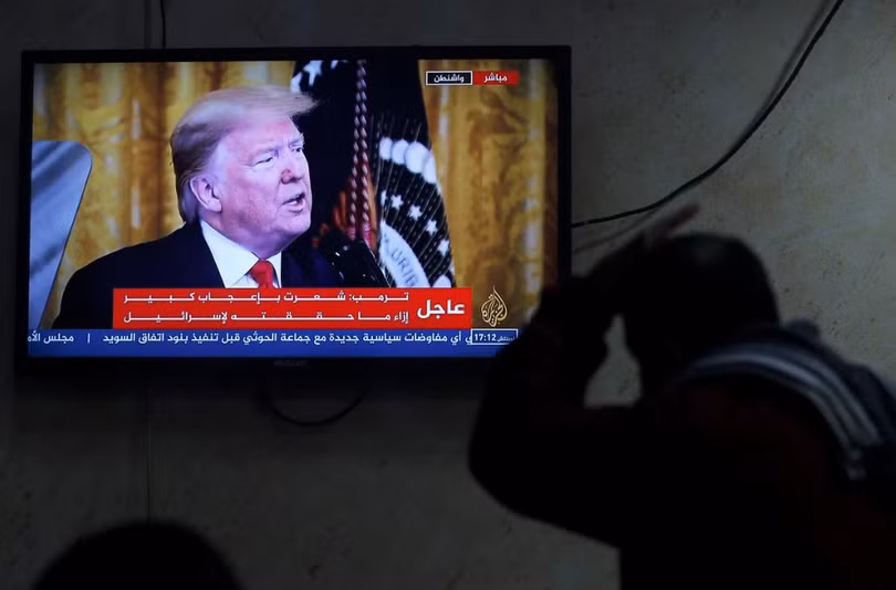 Một người Palestine theo dõi ông Trump tuyên bố kế hoạch hòa bình Trung Đông qua truyền hình (Ảnh: Reuters)