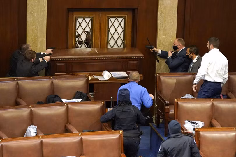 Lực lượng cảnh sát giơ sẵn súng để bảo vệ Hạ viện trước dòng người biểu tình (Ảnh: Suntimes)