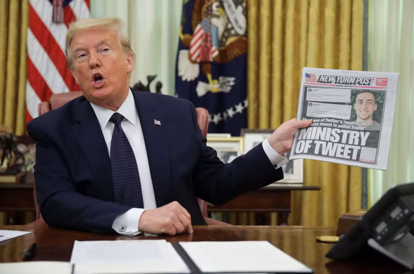 Tổng thống Trump cầm tờ New York Times, trả lời phỏng vấn, trong lúc ký sắc lệnh về các công ty mạng xã hội (Ảnh: CNBC)