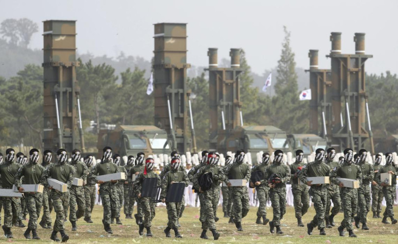 Binh sĩ Hàn Quốc thể hiện kỹ năng chiến đấu, đằng sau là hệ thống Hyunmoo-2 và Hyunmoo-3 (Ảnh: AP)