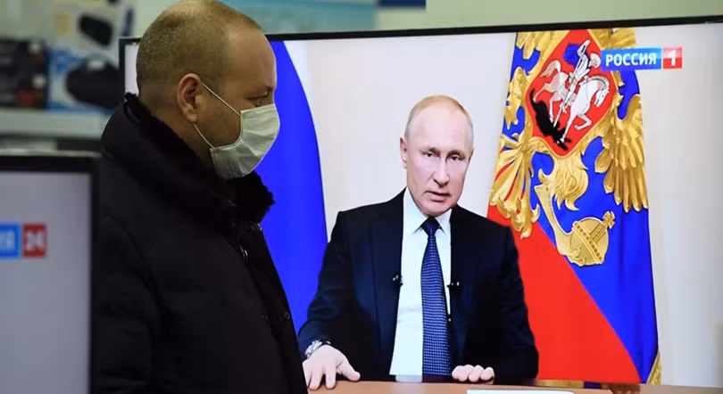 Một người dân theo dõi ông Putin phát biểu trên truyền hình (Ảnh: Sputnik)