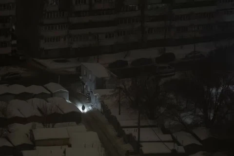 Một người dân ở Kiev dùng đèn pin soi đường khi mất điện sau đòn tấn công bằng tên lửa và UAV của Nga ngày 12/2. Ảnh: Reuters.