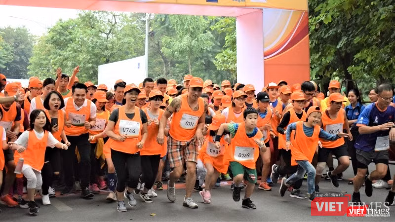 Nhóm mặc áo cam chạy cự ly 5km lao mình ra khỏi vạch xuất phát. Không chỉ người lớn mà nhiều bạn nhỏ cũng hăng hái tham gia thi chạy ở cự ly này.