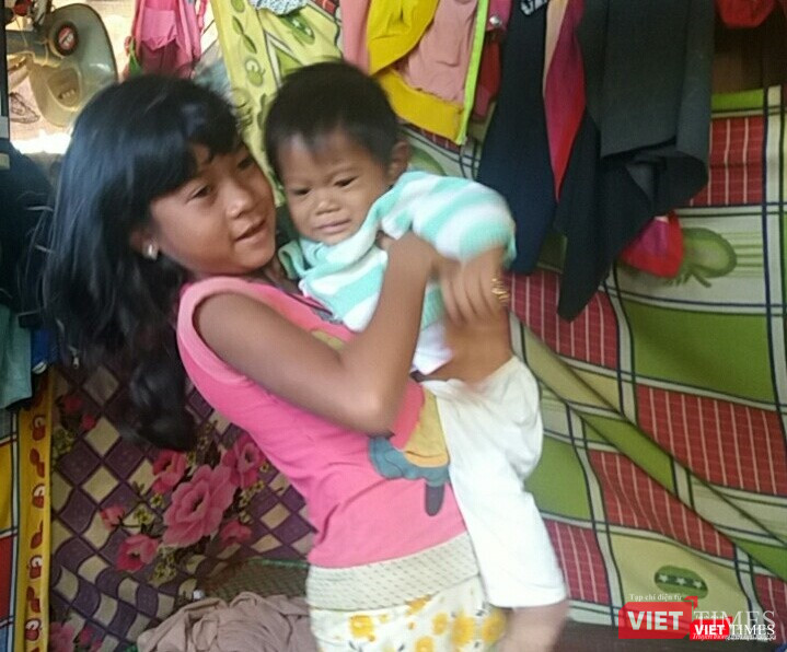 Bé K'Phụng hăng hái trông em cho mẹ đi làm rẫy