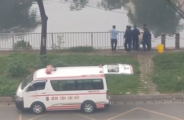 Nhân viên BV Chợ Rẫy thả cá xuống kênh. Ảnh: Cắt từ clip